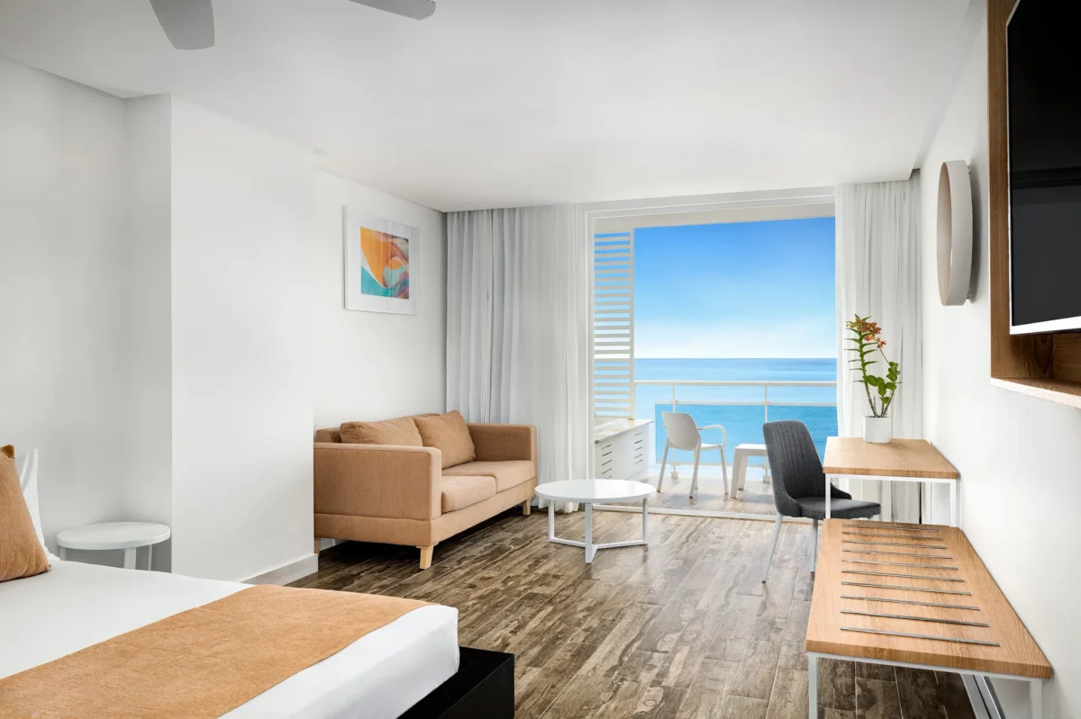 Sun Club Master Suite Ocean Front with king bed, living area, and private balcony overlooking the ocean at Sunscape Dominicus La Romana.