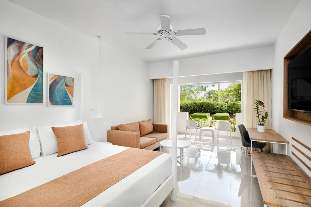 Sun Club Superior Tropical View room with king bed, sofa, and private terrace overlooking the garden at Sunscape Dominicus La Romana.